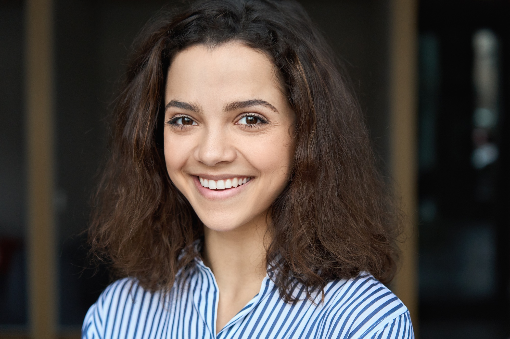 Beautiful happy hispanic young adult 20s woman looking at camera, headshot.