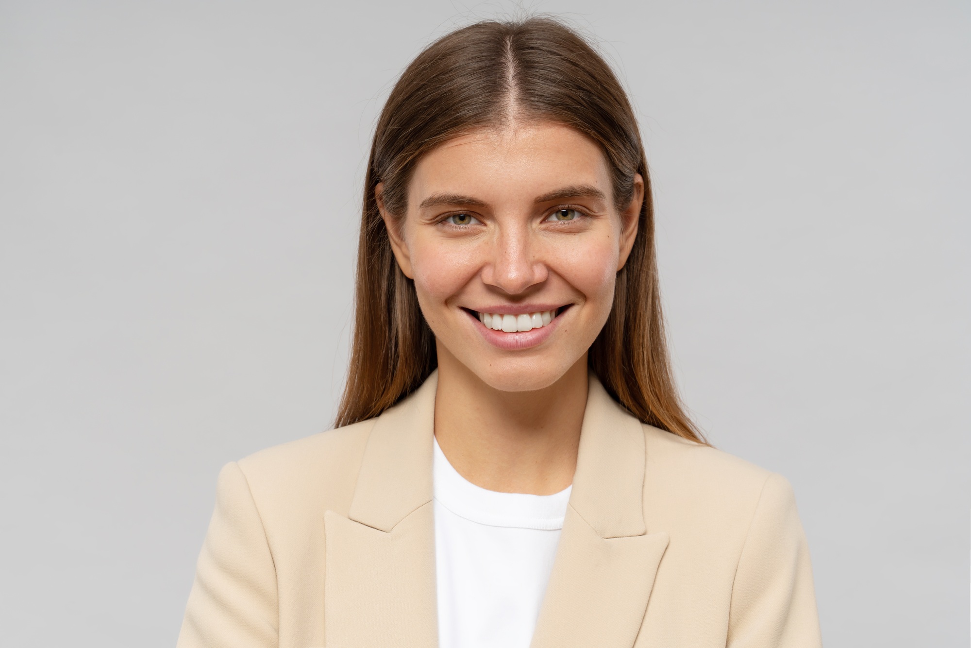 Headshot of smiling successful female student isolated on gray background